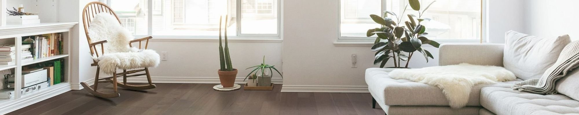 Living room with a sofa and an armchair on a brown hardwood floor from The Carpet Shop - Inspired Floors for Less in Benton Harbor, MI