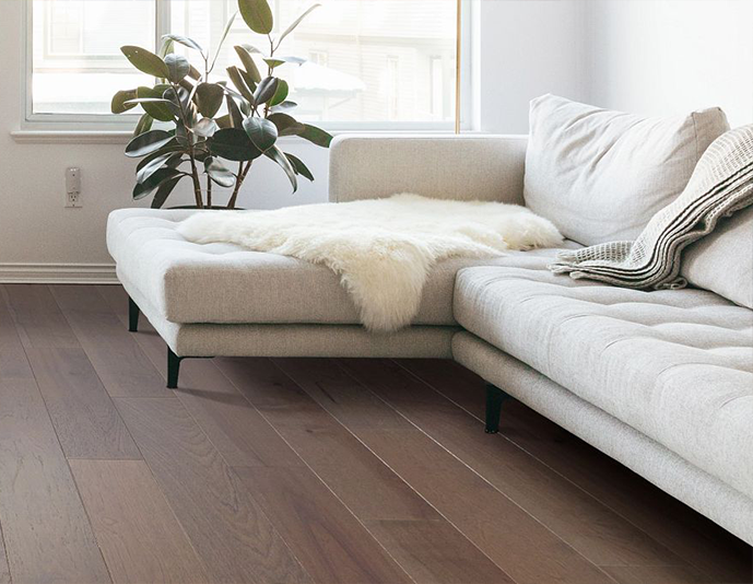 Open space with dark hardwood flooring and White lounge couch by The Carpet Shop - Inspired Floors for Less in Benton Harbor, MI